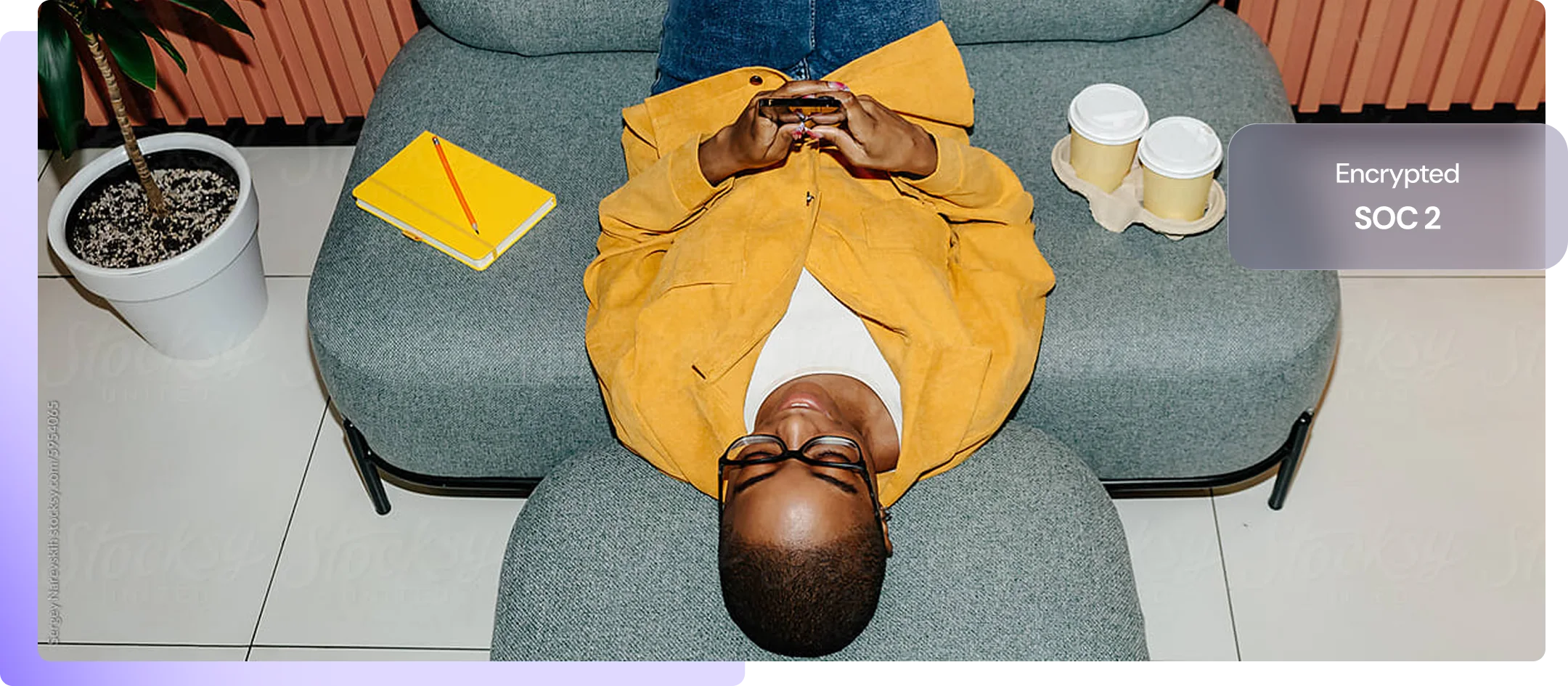 A woman lying on a sofa using her phone, with her contracts encrypted to SOC 2